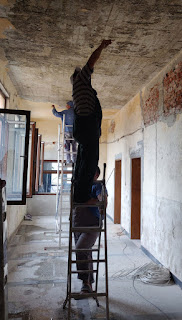 Reaching up to mark a light fitting