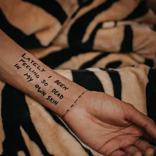 The words, lately I feel so dead in my own skin, written on the forearm of a sad victim of narcissism!