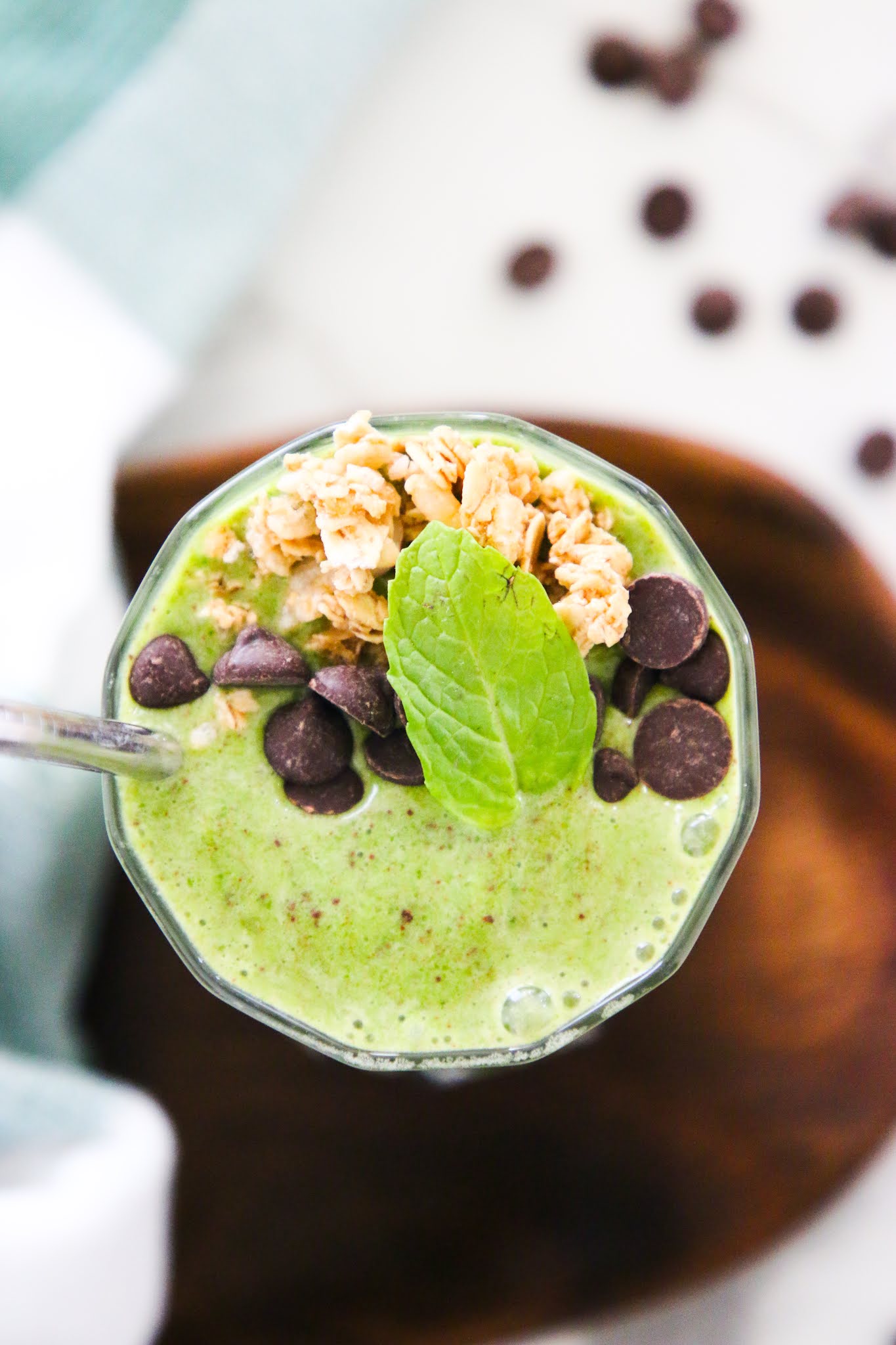 Health shamrock shake smoothie on a marble table top with a metal straw.