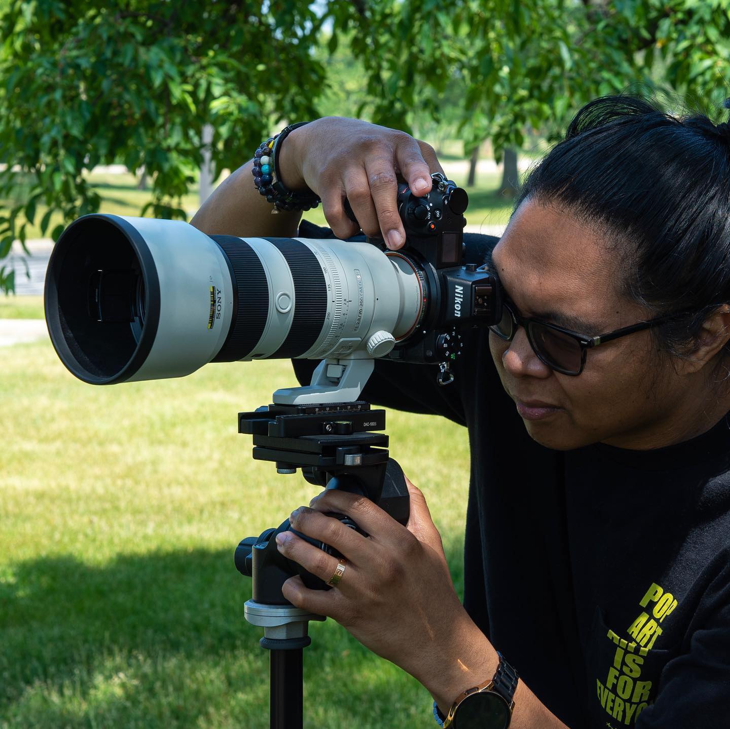 Фотограф держит камеру и объектив Sony установлен на камеру Nikon