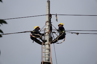 Two utility workers working on an electrical tower | Workplace violence e-learning