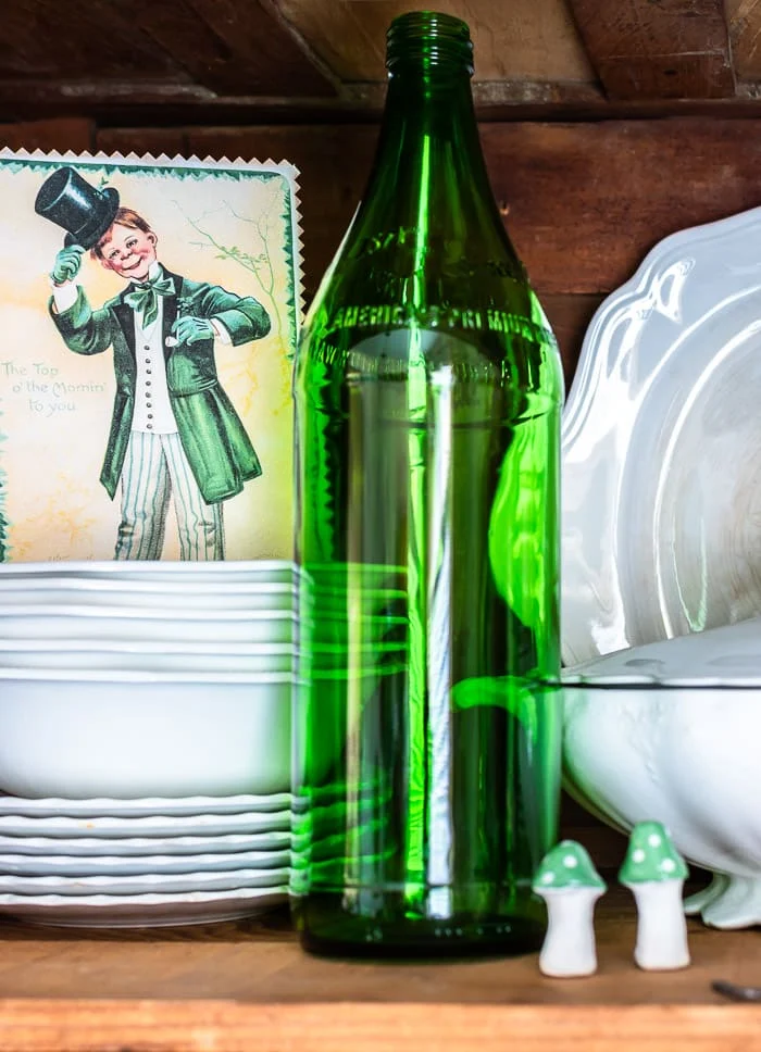green glass bottle, stacks of ironstone, St Patrick's vintage postcard