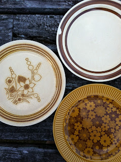 A shot of three old china plates on a picnic table.