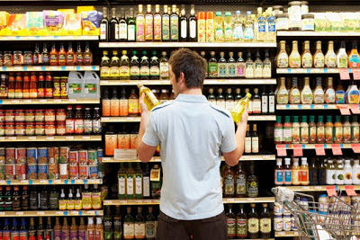 Man comparing store brands at supermarket