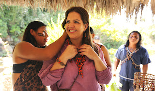 Una turista sonriente disfruta de las artesanías locales, dando la bienvenida a la cultura y tradiciones de UsaYaku.