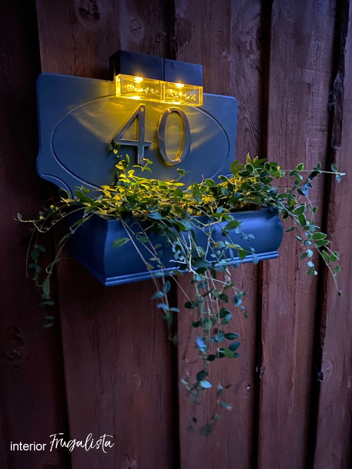 How to build a house number planter box that is backlit at night with solar lights, made from a repurposed Bombay-style jewelry box and wooden plaque.