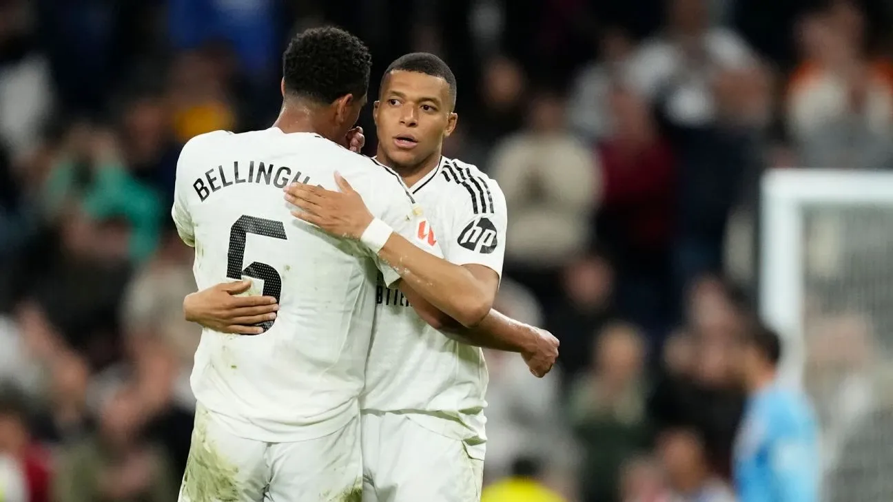 Jogadores Bellingham e Mbappé celebram após um gol durante uma partida de futebol, destacando o entrosamento e a emoção do jogo.