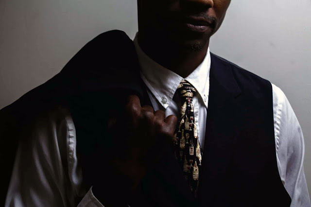 un hombre negro utilizando un traje y corbata