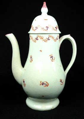 An ornate coffee pot, which looks like a tall thin teapot