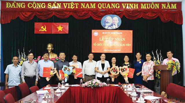 Đồng chí Lê Thị Hồng Nga và đồng chí Vũ Ngọc Tuất trao quyết định, tặng hoa  chúc mừng các chi đảng bộ mới tiếp nhận. (Ảnh: AH)