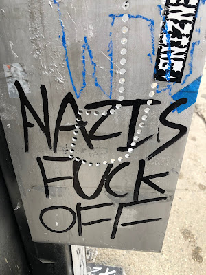 "Nazis Fuck Off" written on side of same telephone booth