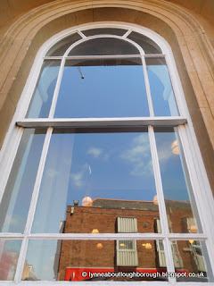 Reflection of phone shop in Town Hall window