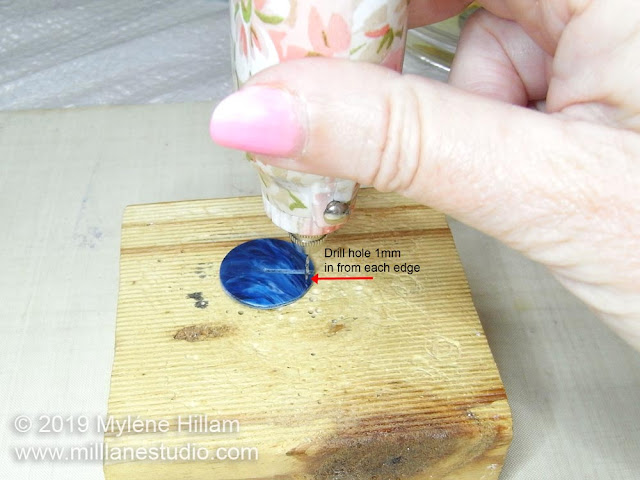 Using the drill to drill a hole in the resin disk.