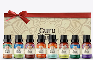 Elegant display of GuruNanda's 100% Pure Essential Oil Gift Set, featuring eight distinct bottles of essential oils, each labeled and arranged to showcase the variety of scents.
