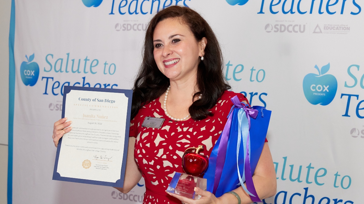 Juanita Nuñez smiles as she holds her San Diego County Teacher of the Year award.