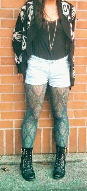 printed black knit cardigan, white shorts, blue patterned fishnets, black combat boots