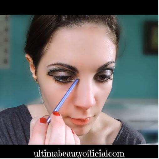 Ultima Beauty using a small eyeshadow brush to apply vanilla pigment to the inner corner of her eye