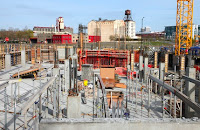 An under construction building with a concrete foundation and some metal structural elements in place.