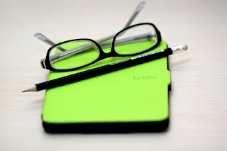 glasses laying on top of kindle