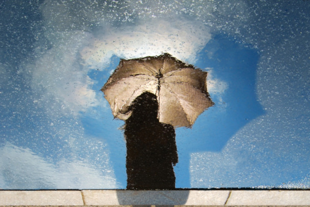 person standing on gray surface while holding umbrella