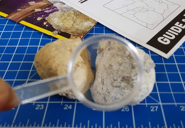 magnifying glass showing close up of geode rock surface 