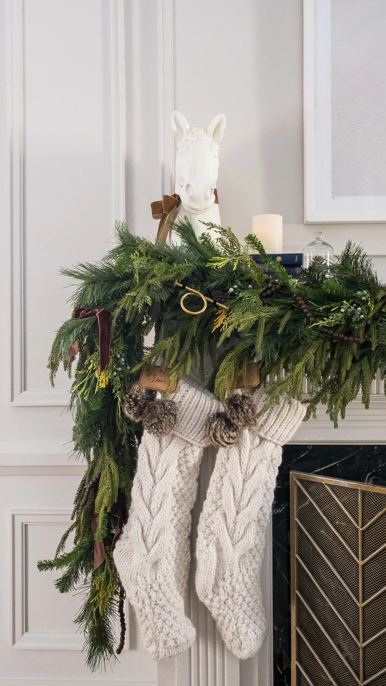 traditional christmas mantel with cable knit stocking, faux garland and velvet bows