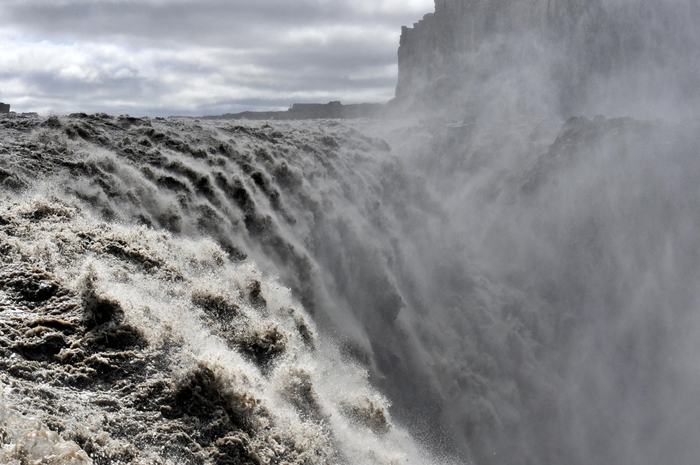 The waterfall Dettifoss is located in Vatnajökull National Park in Northeast Iceland, and reputed to be the most powerful waterfall in Europe. It is also the largest waterfall in Europe in terms of volume discharge, having an average water flow of 193 cubic meter per second. Its volume often increases, especially when the weather or volcanic activity prompts glacial melting on the Vatnajokull glacier icecap. The waterfall is so powerful that it makes the surrounding rocks vibrate, the vibrations can be felt by hand.