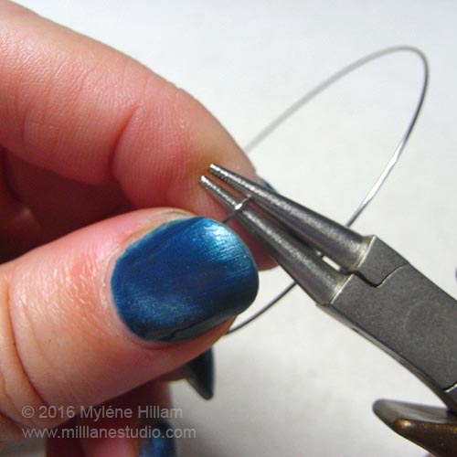 Turning a loop in the memory wire using round nose pliers.