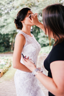 Maquilladora dándole los últimos retoques a la novia