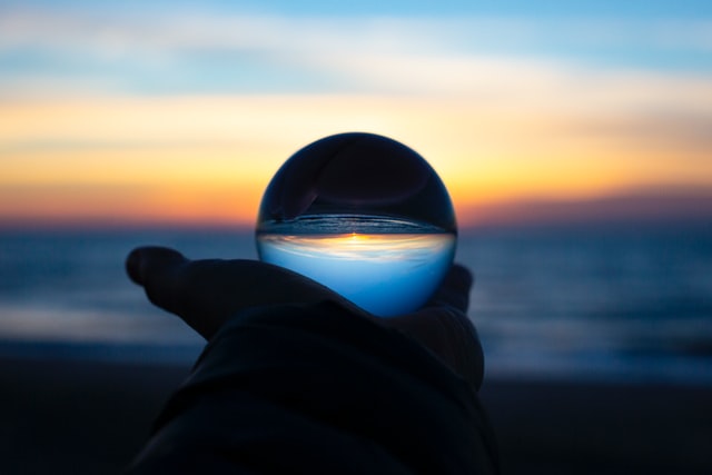 Person holding clear glass ball.