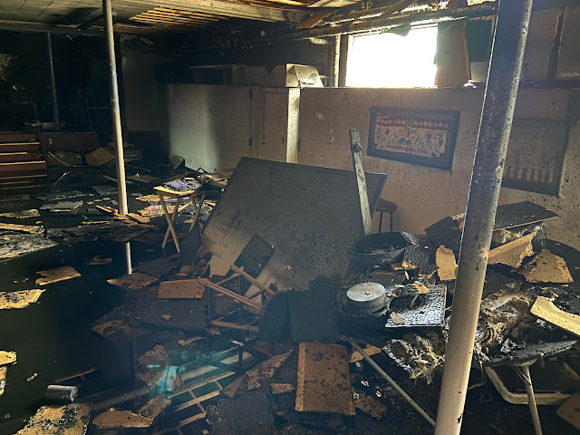 Debris including burned furniture and pictures in temple basement