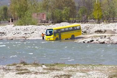 Saatchi Art - Man cleaning school bus in a mountain stream on the outskirts of Srinagar
