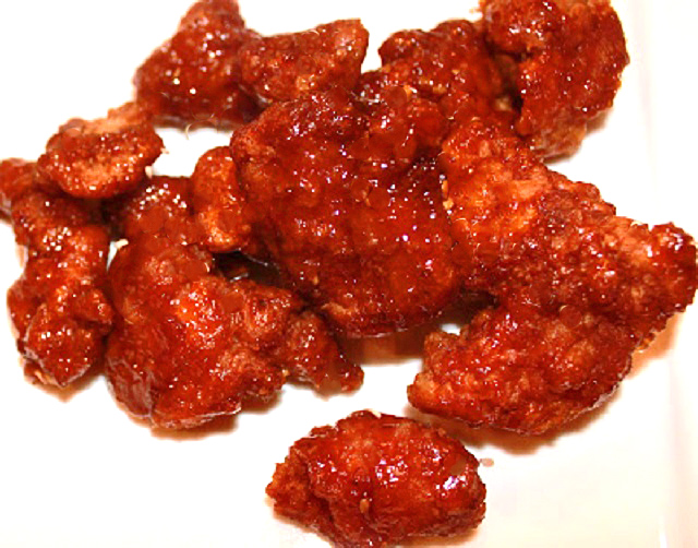 orange chicken on a white plate Asian style coated