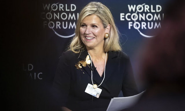 Queen Maxima wore a black jumpsuit by Natan. Celedonio gold butterfly brooch. Monies Jewellery gold earrings