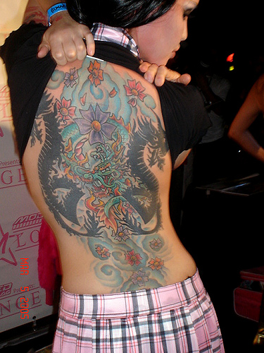 Young girl with a japanese style dragon tattoo in her back