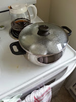 Pot with lid on and water covered jars inside starting to boil.