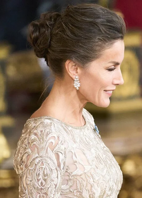 Queen Letizia wore a crochet lace and cape sleeves floor-length silver gown. President Isabel Diaz Ayuso