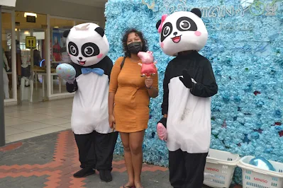 "Shachem Lieuw standing with the Tian You mascots in Hermitage mall Paramaribo"