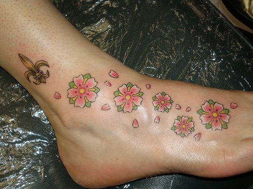 Cupcake ankle and foot tattoo Saints logo with flowers tattoo