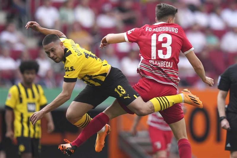 Dortmund s Raphael Guerreiro, left, challenges Augsburg s Elvis Rexhbecaj for the ball during the German Bundesliga