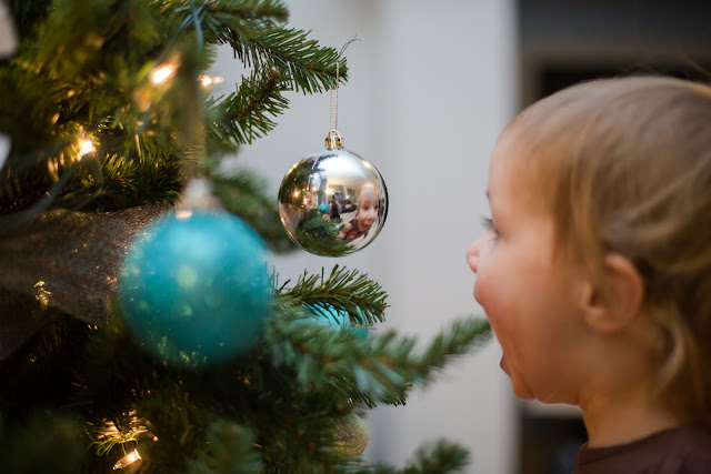 Child looking at reflection in ornament