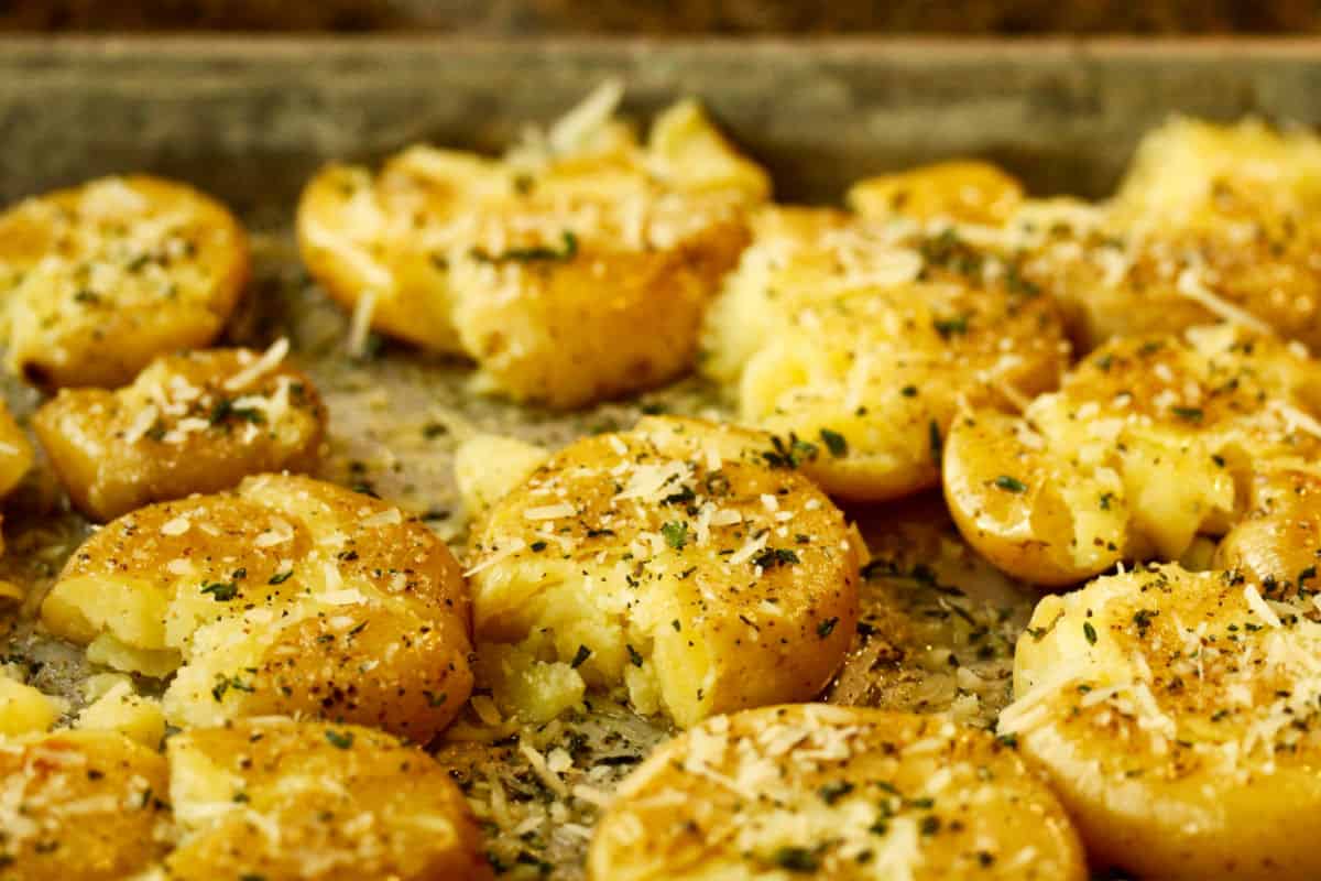 Smashed Potatoes with herbs and cheese in the pan after roasting.