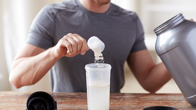 Close up of Man with Protein Shake Bottle and Jar