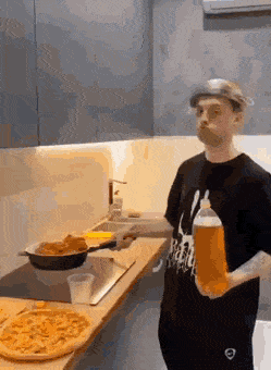 Mann mit Bier macht extrem ungeschickt Essen in der Küche