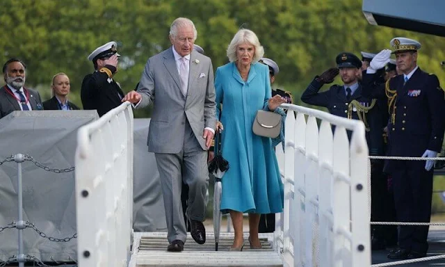 Queen Camilla wore a blue dress coat, and floral print midi dress. Diamond brooch. HMS Iron Duke