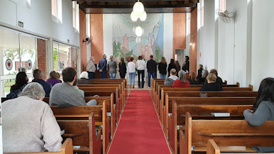 Os membros da nova diretoria se perfilam diante do altar.