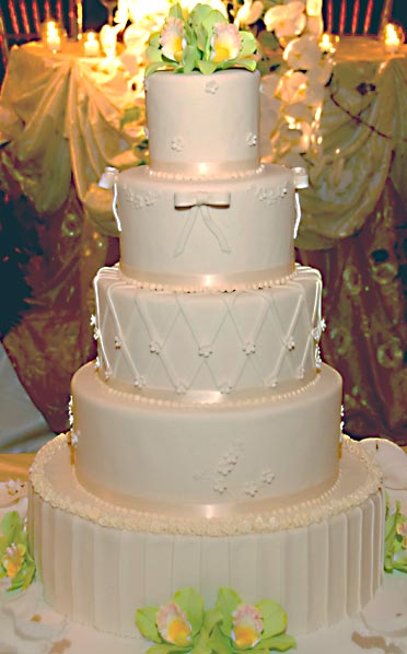 Beautiful traditional white wedding cake set over 5 differently textured and