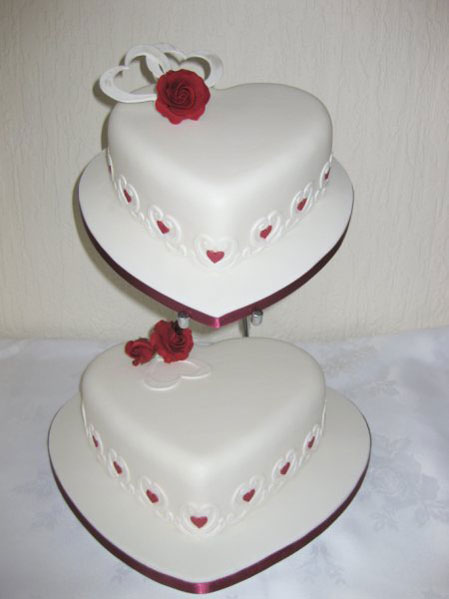Heart white wedding cake with diamontes and dark blue sugar roses