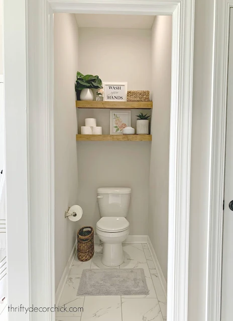 stained floating shelves above toilet