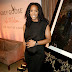 Pregnant Kelly Rowland lays a protective hand on her growing baby bump as she poses with Beyonce's mom Tina Knowles 